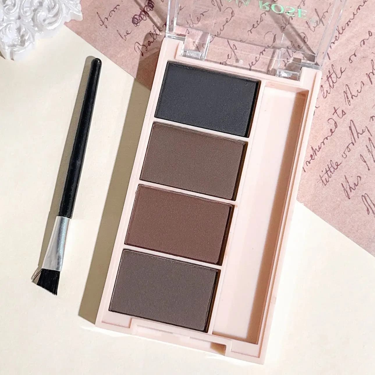 Un ensemble de plateaux de poudre à sourcils de 4 couleurs avec des pinceaux en tons gris et marron 