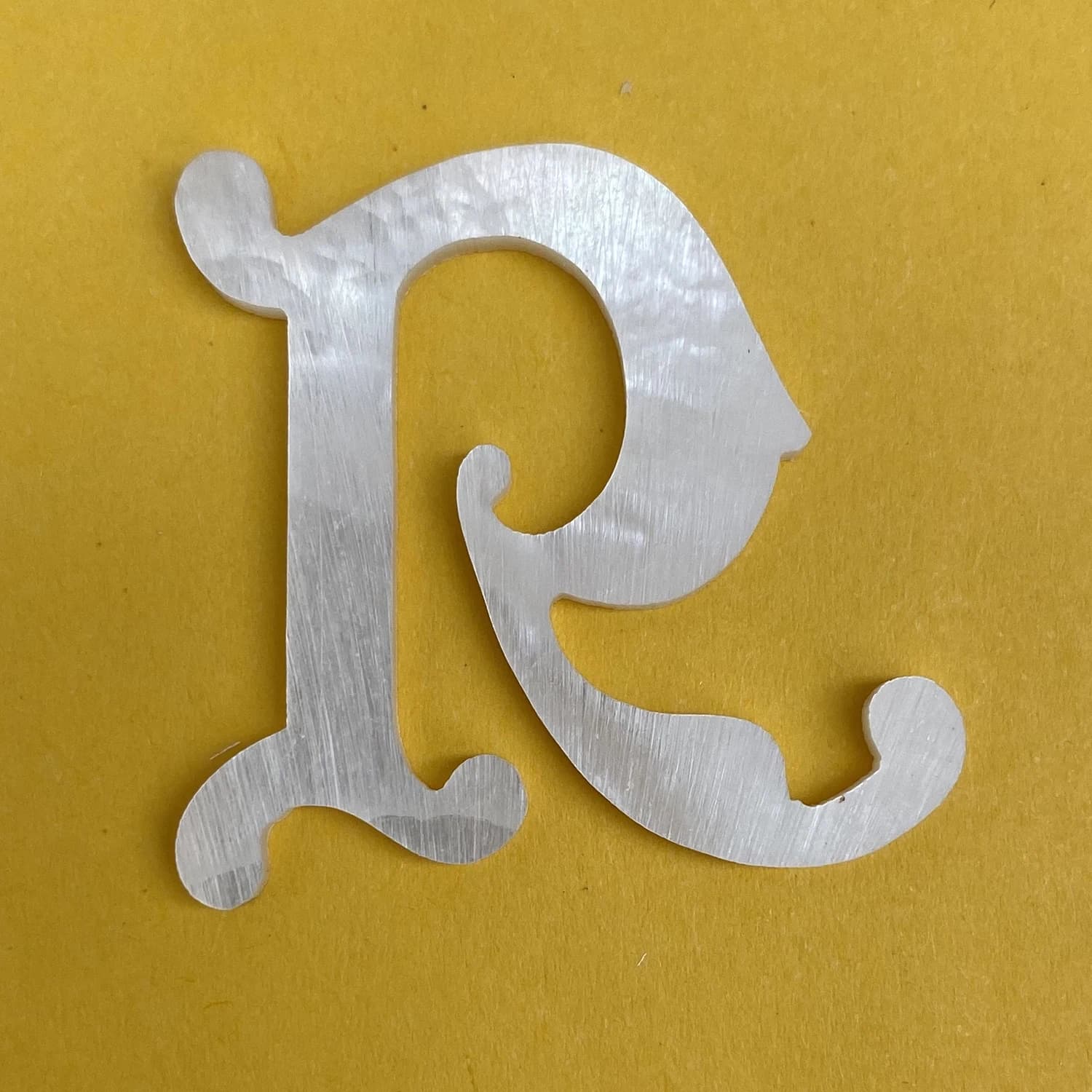 Logo en nacre solide avec incrustation R de 2 mm d'épaisseur